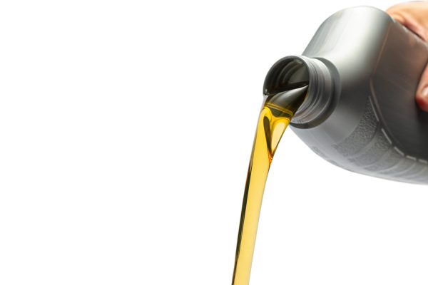 hand Pouring oil lubricant motor car from a bottle on isolated w ideal for websites and magazines layouts